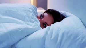 Donna spaventata a letto (canva) Adginforma.it