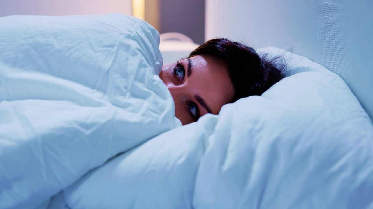 Donna spaventata a letto (canva) Adginforma.it