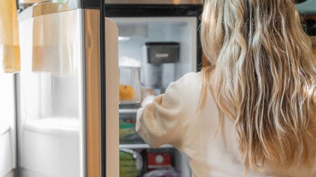 Donna guarda in frigo